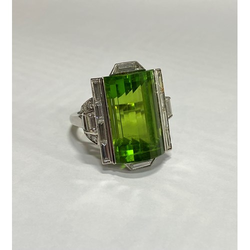 Late Art Deco fancy peridot and diamond dress ring, c.1940, the rectangular peridot arch-topped and step line facetted,